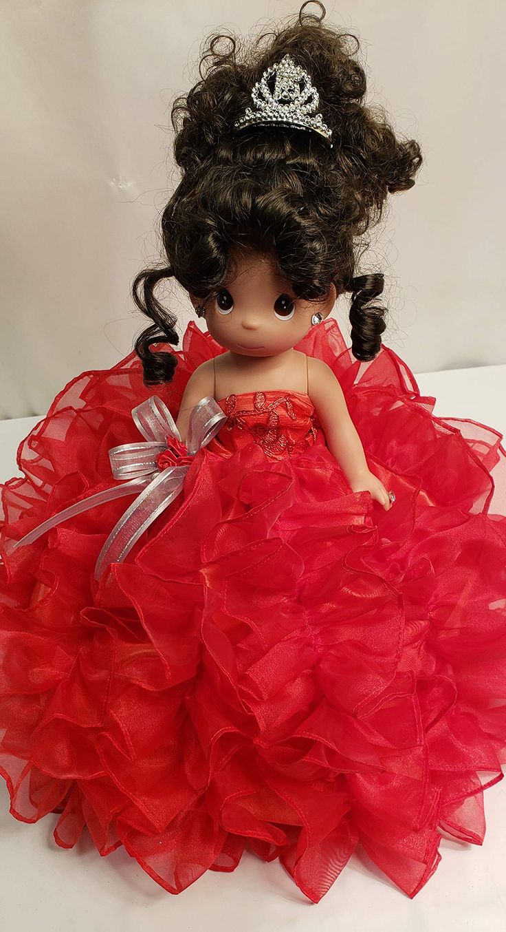 a doll wearing a red dress with a tiara on it's head and hair