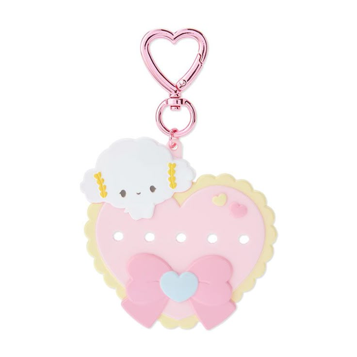 a pink heart shaped keychai with a sheep on it's back and a bow around the neck