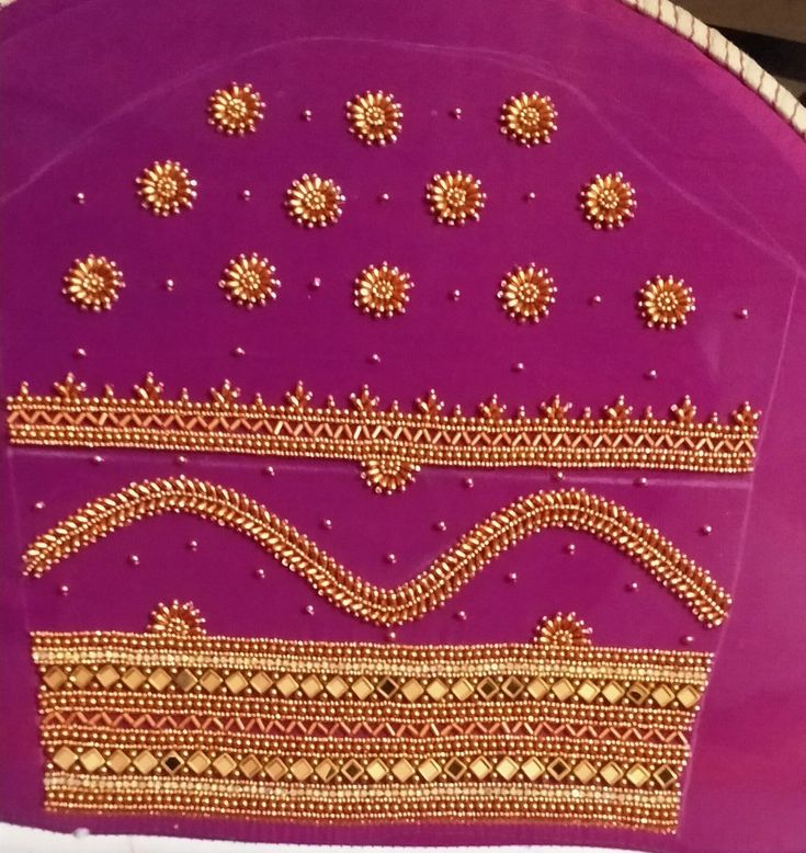 a purple cloth with gold designs on the side and some beads in the middle, sitting on a table