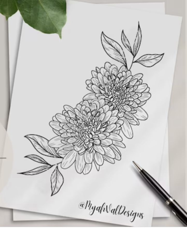 some flowers are sitting on top of a piece of paper next to a pen and ink