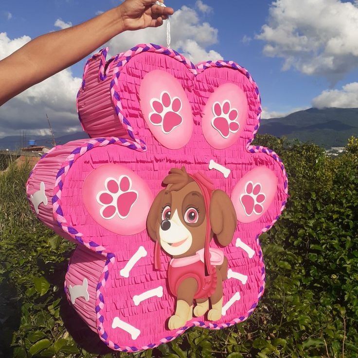 a person holding up a pink dog pinata