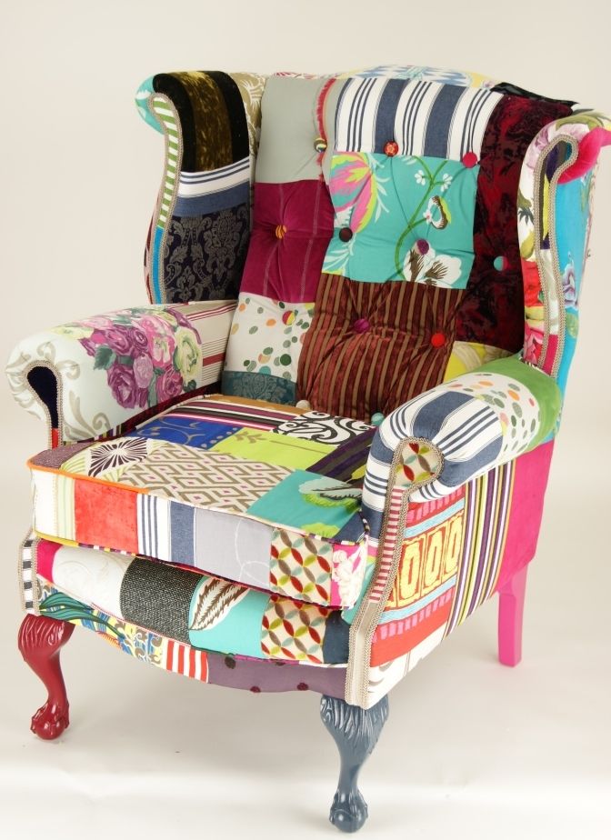 an upholstered chair with colorful fabrics on it's back and arms, sitting in front of a white background