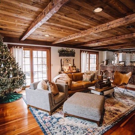 a living room filled with furniture and a christmas tree in the middle of the room