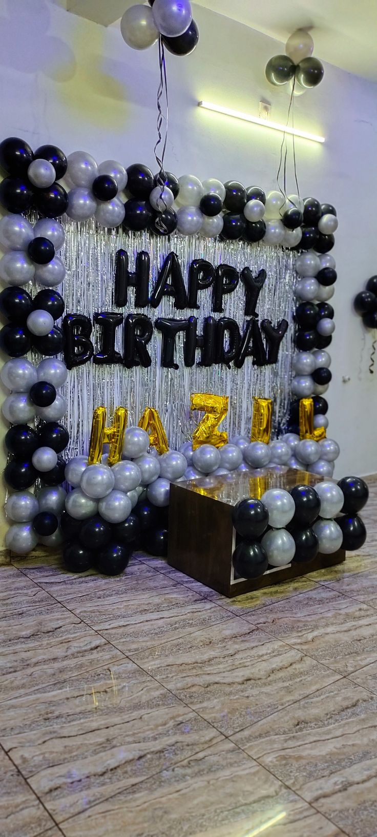 a birthday party with balloons and streamers on the floor in front of a sign that says happy birthday