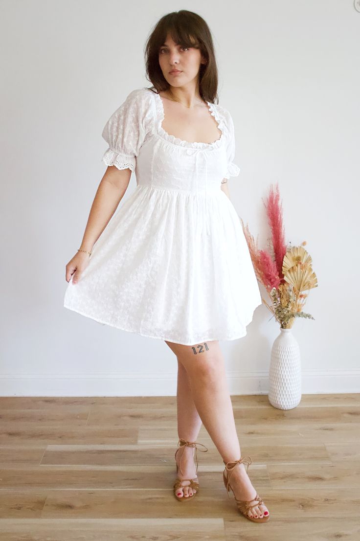 This Feona eyelet dress is the perfect summer addition to your wardrobe! Made with lightweight and breathable fabric, it features intricate eyelet details for a touch of elegance. The flowy design and comfortable fit will keep you feeling stylish and cool all day long. Feminine Midi-length Eyelet Dress, Feminine Midi Length Eyelet Dress, Feminine Flowy Swiss Dot Dresses, Feminine Eyelet Midi Dress, Feminine Eyelet Dress With Short Sleeves, Fitted Eyelet Midi Dress For Summer, Lace Trim Midi Dress For Day Out, Summer Lace Eyelet Mini Dress, Eyelet Mini Dresses For Day Out