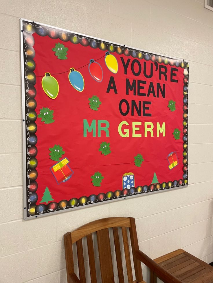 a red bulletin board hanging on the side of a wall next to a wooden bench