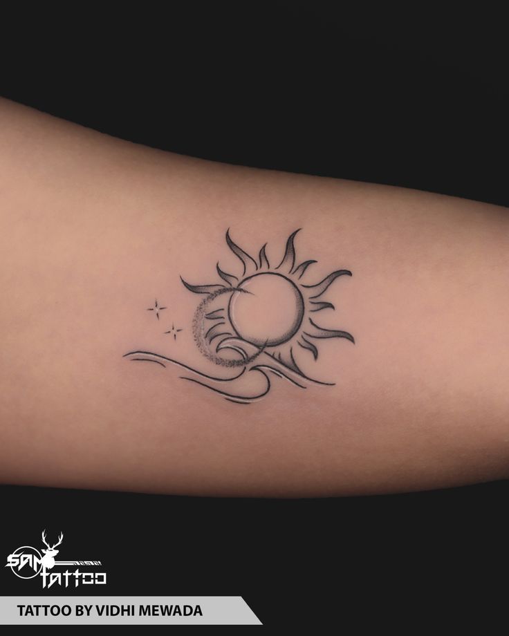 a tattoo on the arm of a woman that has a sun and moon in it