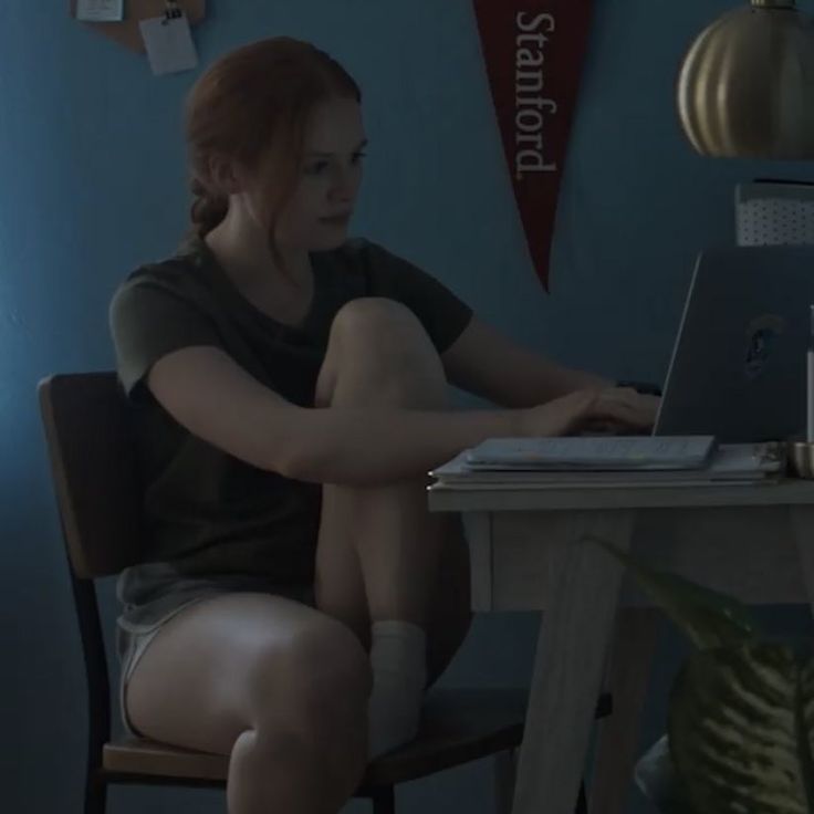 a woman sitting in front of a laptop computer