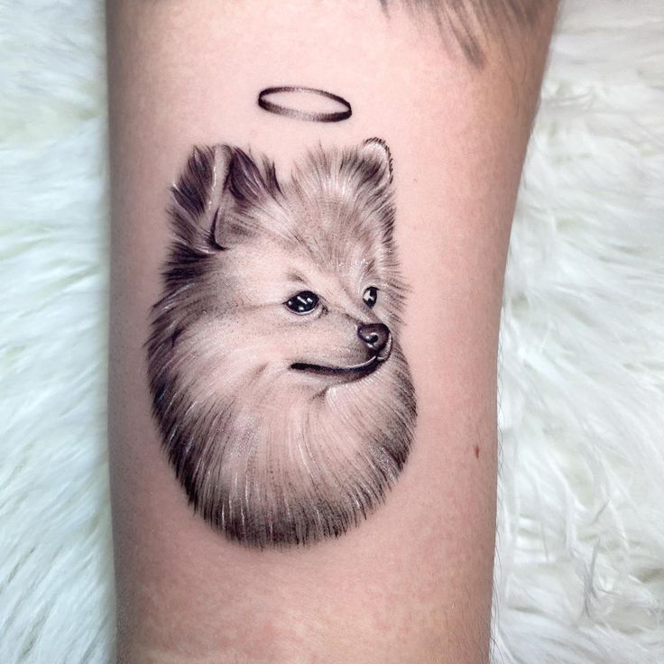 a small dog with an angel halo on its head is shown in this tattoo design