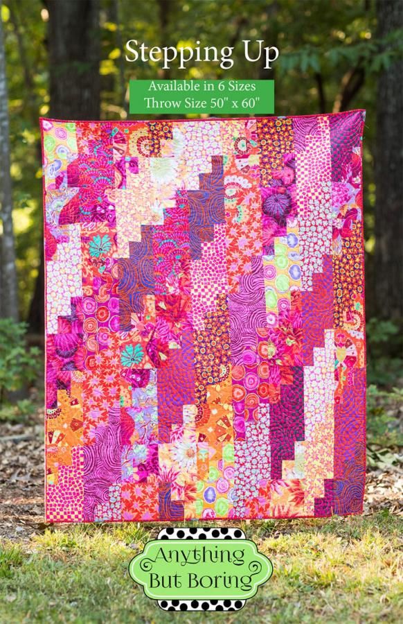 a colorful quilt on the grass with trees in the background and text saying, stepping up available