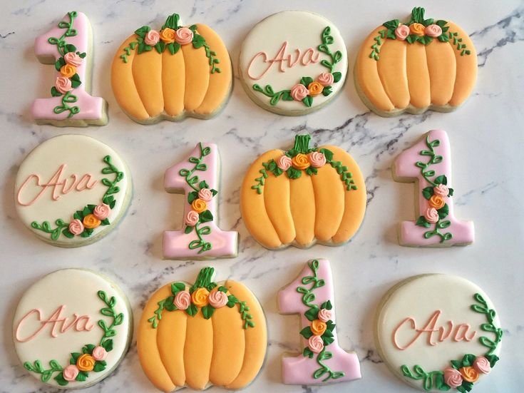 decorated cookies are arranged on a marble countertop with the letters and numbers for each cookie