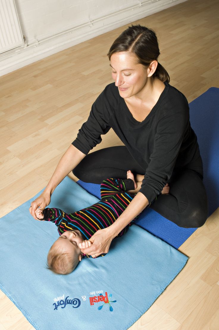 a woman is sitting on the floor with her baby