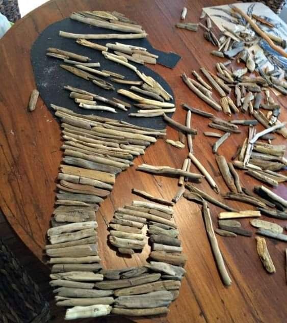 a wooden table topped with lots of sticks and wood shavings on top of it