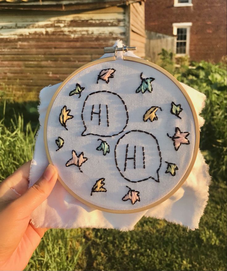 someone is holding up a hand embroidered hoop with the letters h and o on it