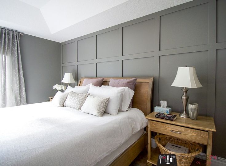 a bedroom with gray walls and white bedding