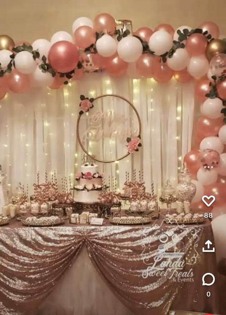 a table topped with lots of pink and white balloons