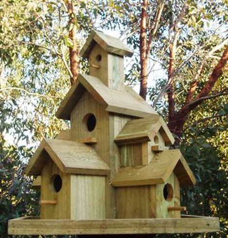 a wooden bird house in the middle of some trees