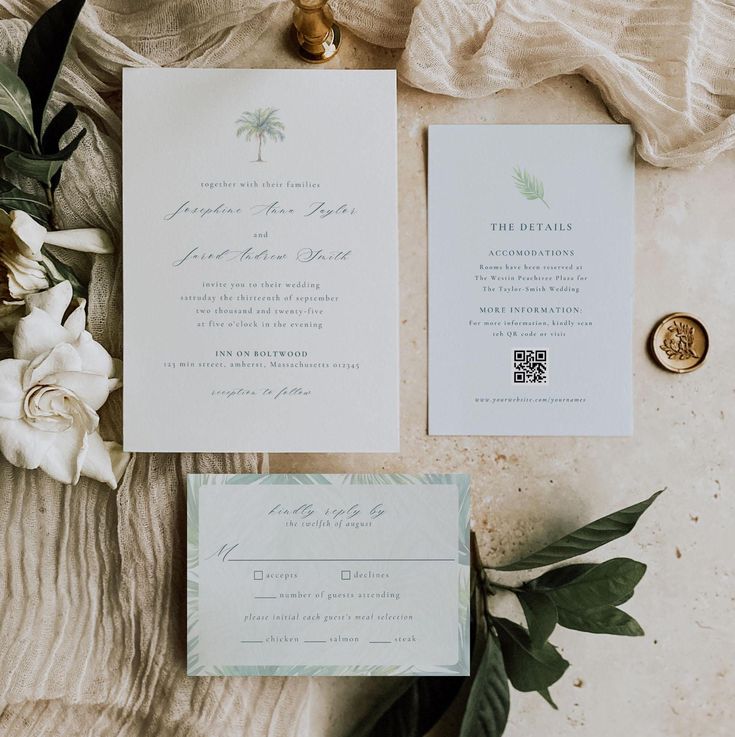 the wedding stationery is laid out on top of the table with flowers and greenery