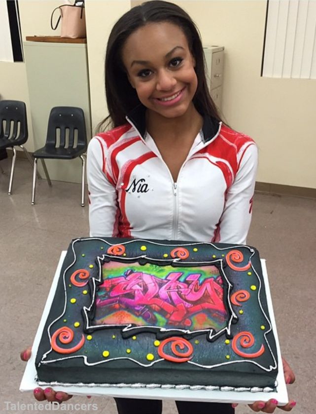 a woman holding up a cake in her hands