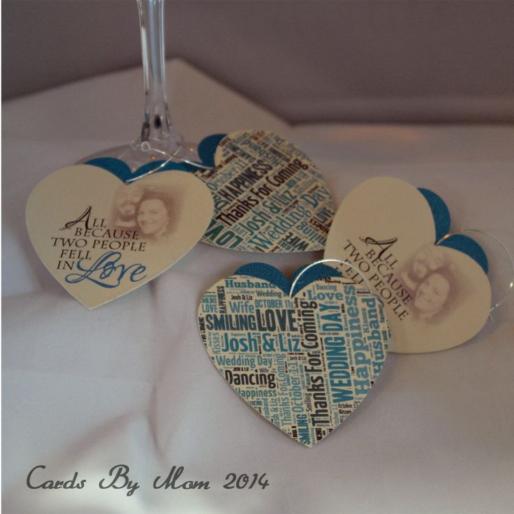 three heart shaped wine glasses sitting on top of a white tablecloth covered table cloth