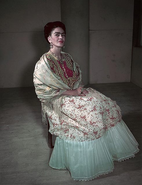 a woman sitting in a chair wearing a dress