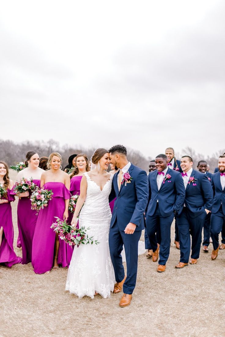 a bride and groom kissing in front of their wedding party