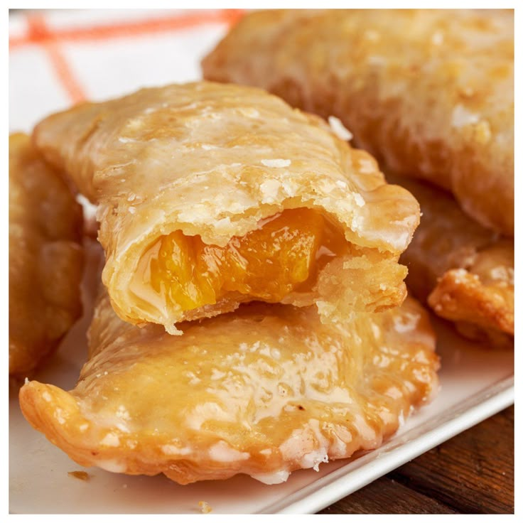 there are several pastries on the plate and one is filled with orange fillings