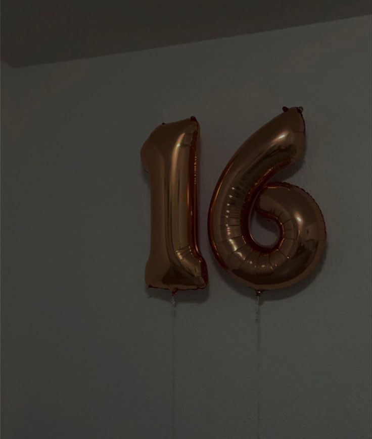 the number sixteen balloon is hanging on the wall