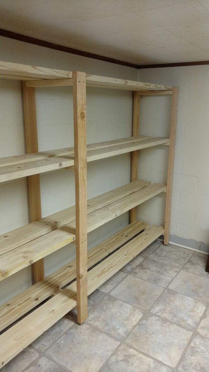 empty wooden shelves in the corner of a room with tile flooring and white walls