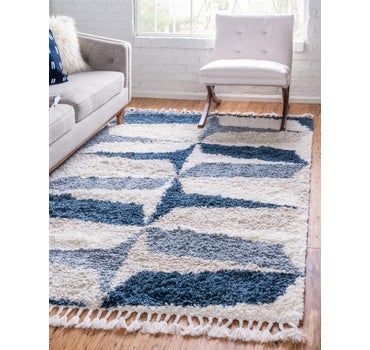 a blue and white rug in a living room with a couch, chair and window