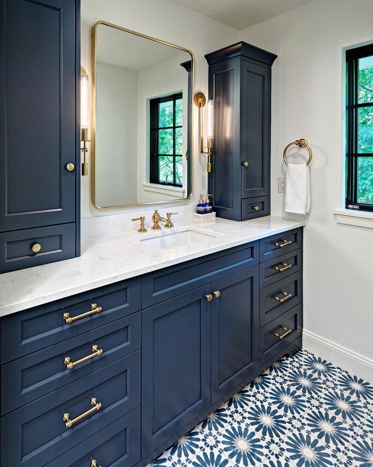 a bathroom with blue cabinets and white counter tops