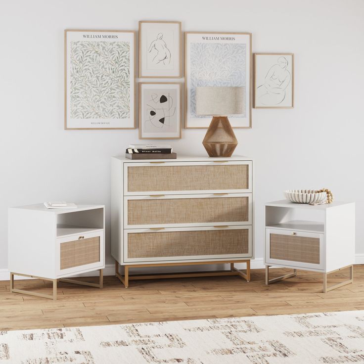 a white dresser and two side tables with pictures on the wall behind it in an empty room