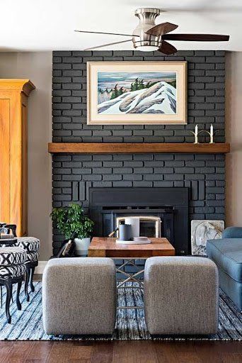 a living room with two couches and a fireplace in the corner, along with a painting on the wall