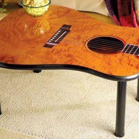 a guitar shaped coffee table sitting on top of a carpeted floor