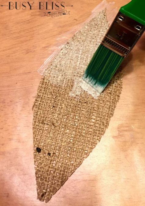 a green paint brush sitting on top of a piece of burlied fabric next to a wooden table