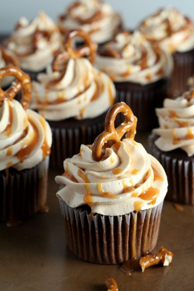 chocolate cupcakes with white frosting and pretzels on top, ready to be eaten