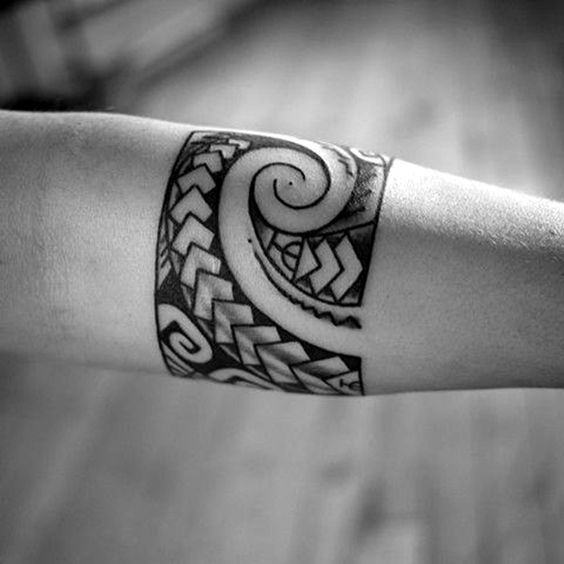 a woman's arm with a tattoo design on the arm and wrist, in black and white