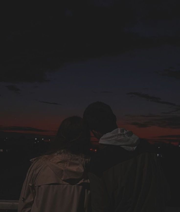 two people looking at the night sky with their backs to each other and one person standing in front of them