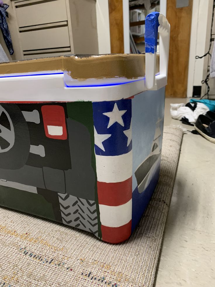 a large cooler with an american flag design on the front and side, sitting on top of a table