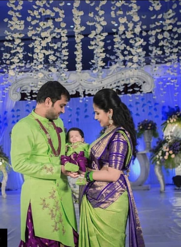 a man and woman standing next to each other in front of a stage with chandelier