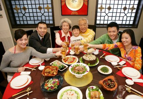 a group of people sitting around a table with food and drinks in front of them