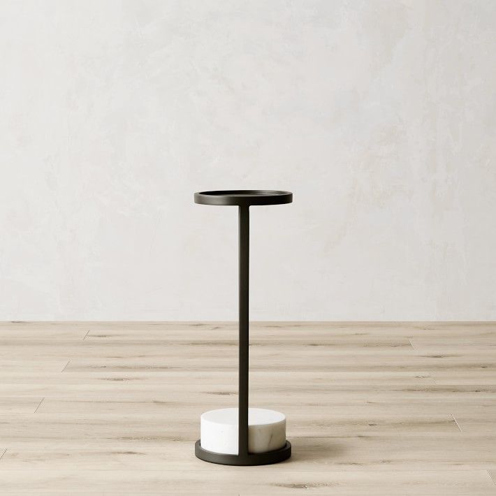 a black and white table with a wooden floor in front of a plain wall behind it