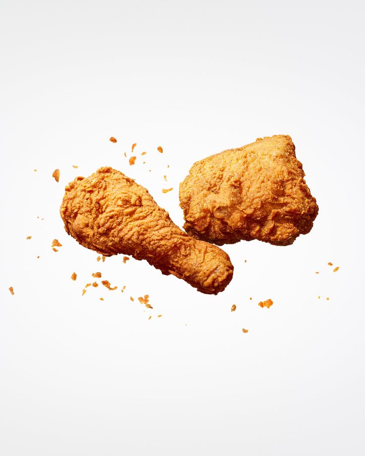 two pieces of fried chicken on a white background