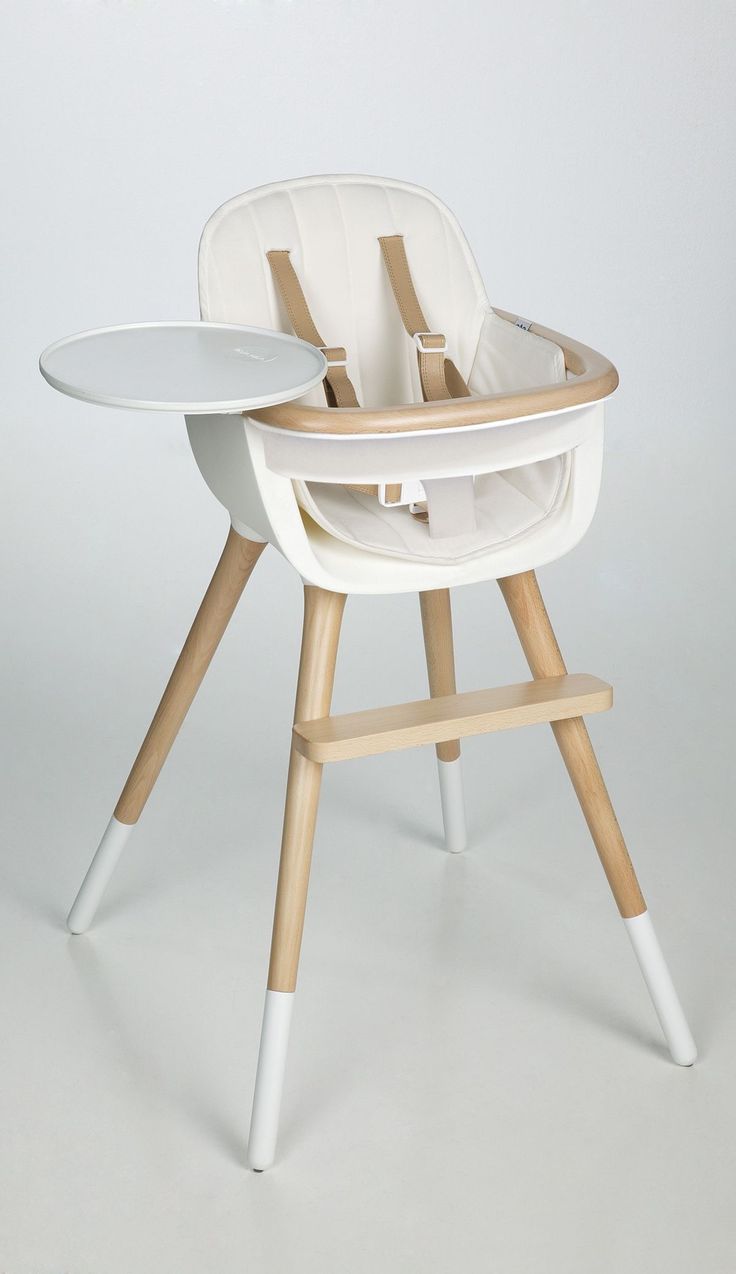 a white high chair sitting on top of a wooden table