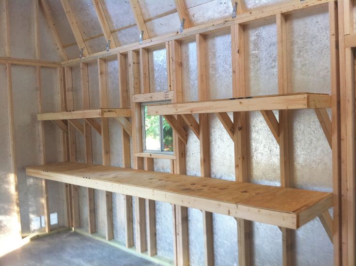 the inside of a building with wooden shelves and walls that are being built into the wall