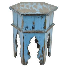 an old blue wooden side table with peeling paint on the top and bottom, against a white background