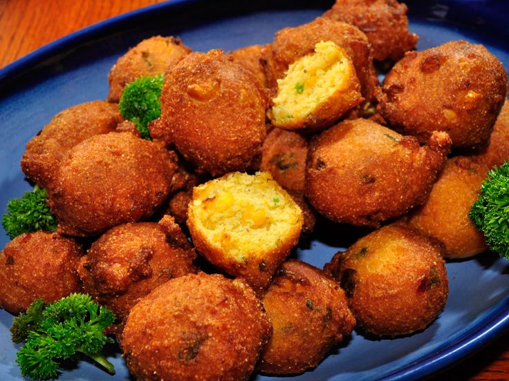 a blue plate topped with tater tots and broccoli on top of a wooden table