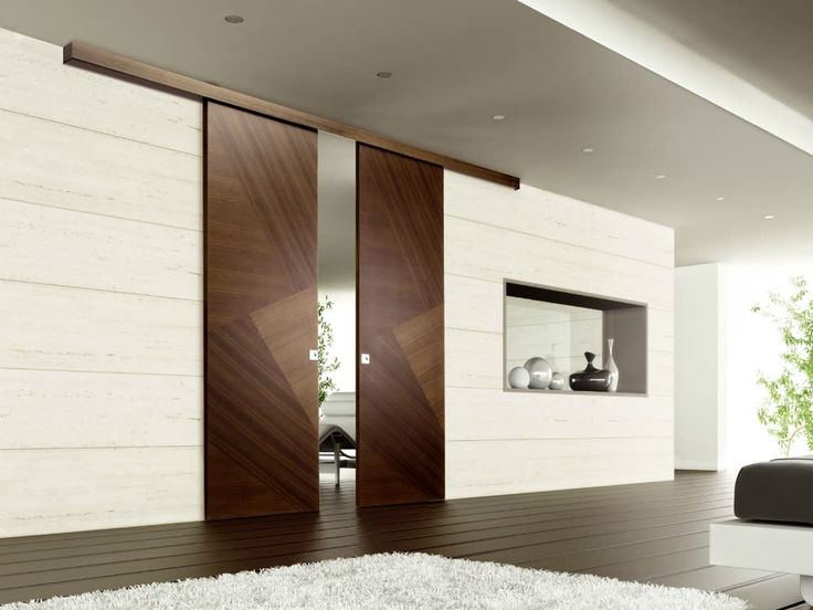 a modern living room with sliding doors and white rugs on the hardwood flooring