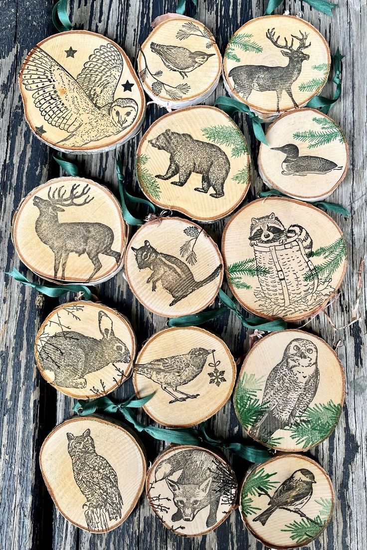 wooden ornaments with animals and birds on them are hanging from green ribbon tied to wood planks