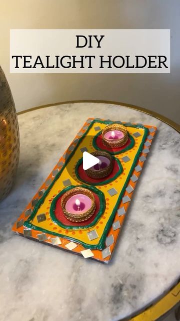 a candle holder sitting on top of a marble table next to a vase with candles